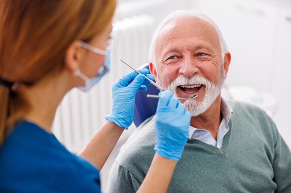 An older person is getting a dental treatment